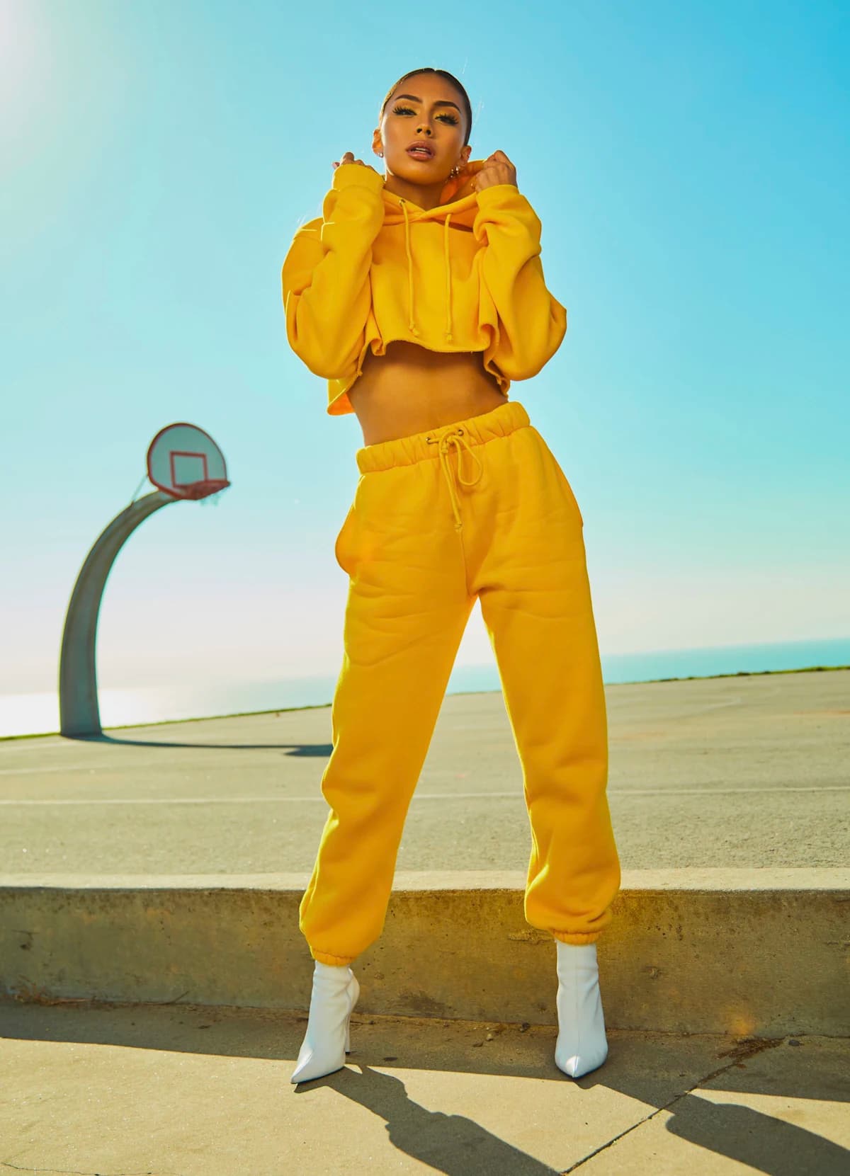 Woman in a yellow hoodie and joggers outdoors